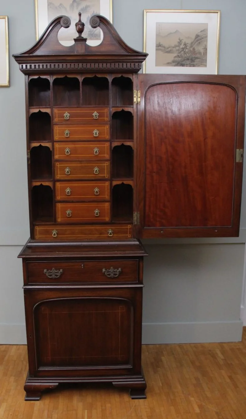 Cabinet - Meubel › Kasten - €1350.00 - Smal tweedeurs cabinet in mahoniehout met twee deuren boven elkaar. De binnenkant van het bovendeel is ingericht met zeven kleine laden en pigeonholes met gotic revival boogjes. Oorspronkelijke trekkers. Ogee bracket feet. In het geheel een eclectische vormgeving met grotendeels stijlelementen van de Georgean periode.
61 x 41cm; 180cm hoog
Laatvictoriaanse periode; ca 1880/1900
