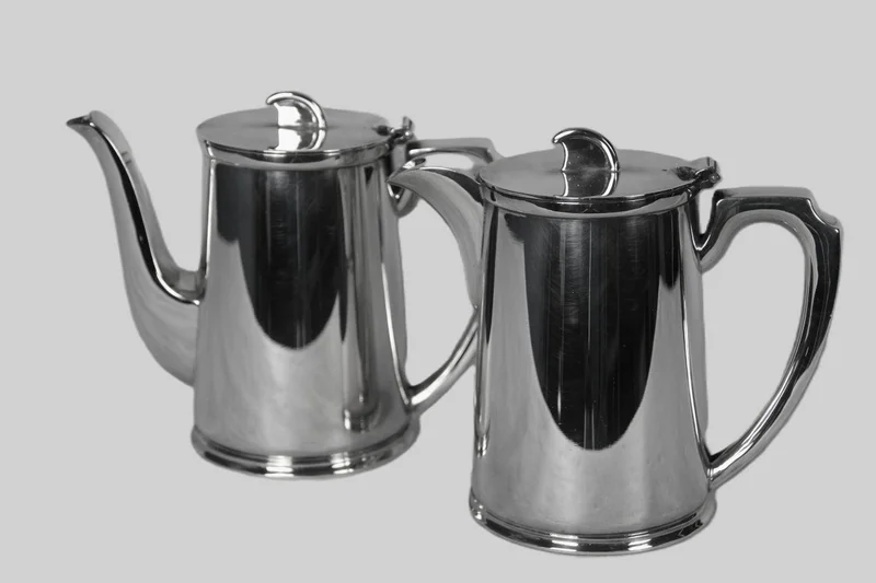 Koffie- en warmwaterkennetje - Zilver › Serviesgoed - Paar verzilverde kannetjes van elk 1 pint inhoud.
Eén koffiekan en één warmwaterkan.
Gemerkt Walker & Hall, Ai verzilvering (zware verzilvering).
Ca 1940
