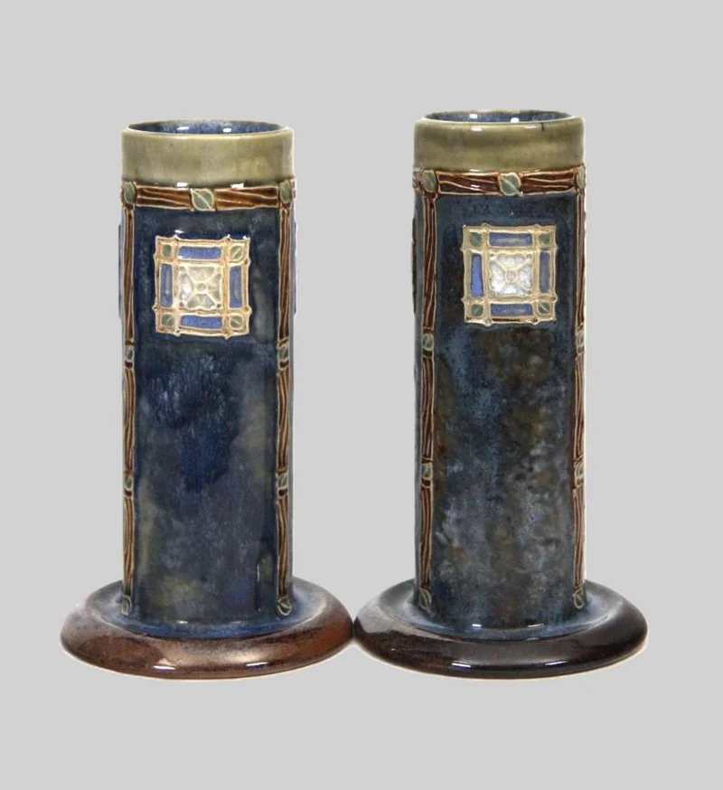 Paar Royal Doulton kokervazen - Porselein › Vazen - €265.00 - Paar kokervazen in overwegend blauwgroene kleur.
10.5cm diameter aan de voet, 18.5cm hoog
Gemerkt Royal Doulton 1902-1932