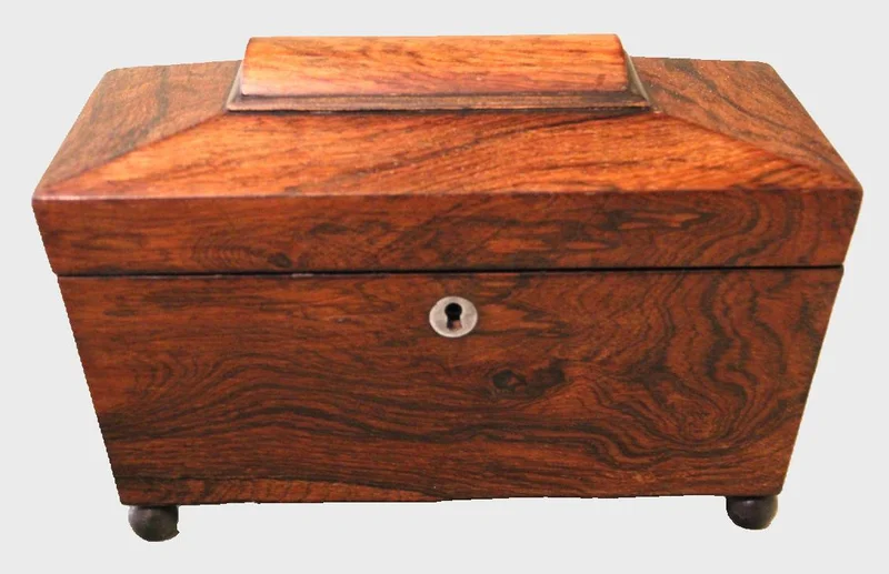 Palissander theacaddy - Diversen › Dozen en kistjes - €195.00 - Georgean theacaddy in palissanderhout. Binnenin twee theevakjes naast een centraal geplaatst mengglas. Mengglas later vervangen.
27.5 x 13cm   17cm hoog
Ca 1800