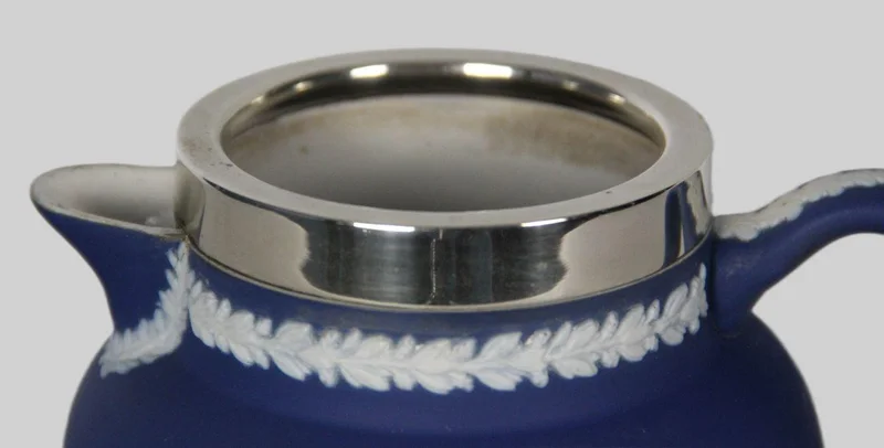 Roomkan in Wedgewood motief (1) - Porselein › Serviesgoed - Een roomkan met decoratie in Wedgewood stijl. Een verzilverde kraag.
Gemerkt: Tunstall England, Adam
12cm hoog
19e eeuw