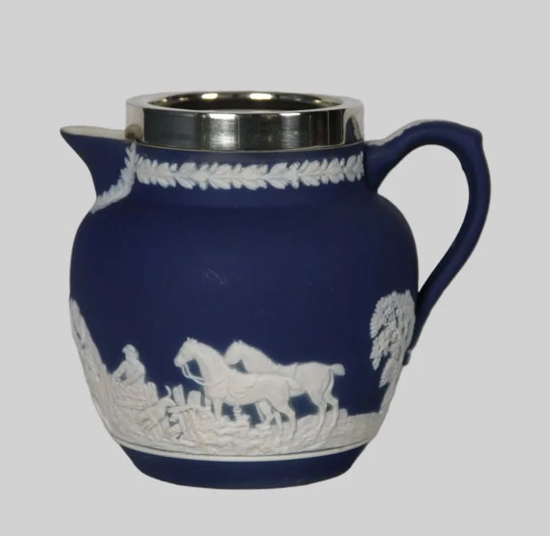 Roomkan in Wedgewood motief (1) - Porselein › Serviesgoed - Een roomkan met decoratie in Wedgewood stijl. Een verzilverde kraag.
Gemerkt: Tunstall England, Adam
12cm hoog
19e eeuw