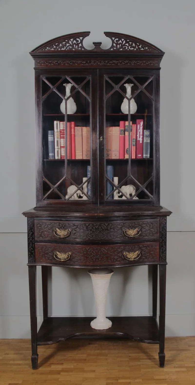 Victoriaans cabinet in Chippendale stijl - Meubel › Kasten - €750.00 - Klein tweeledig cabinet met een lowboy en opzetvitrine. Mahoniehout gedonkerd. Druk vlak snijwerk in laden en op kap (zgn Chippendale stijl). Originele trekkers in gedreven messing.
76cm breed, maximaal 45cm diep, 180cm hoog.

Victoriaans tijdperk, ca 1870/1880