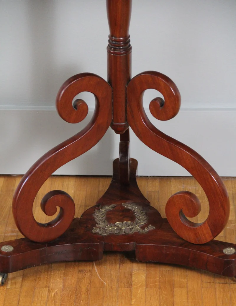 Vroegvictoriaans bijzettafeltje - Meubel › Tafels - €695.00 - Bijzettafeltje in cubaans mahonie op driespant, liermotieven en bronzen lauwerkrans.
63.5 x 42.5cm, 68.5cm hoog
Vroegvictoriaanse periode, ca 1830/1840
Gepolitoerd op oude wijze
